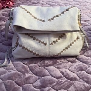 Cream shoulder bag with tan and gold accents.